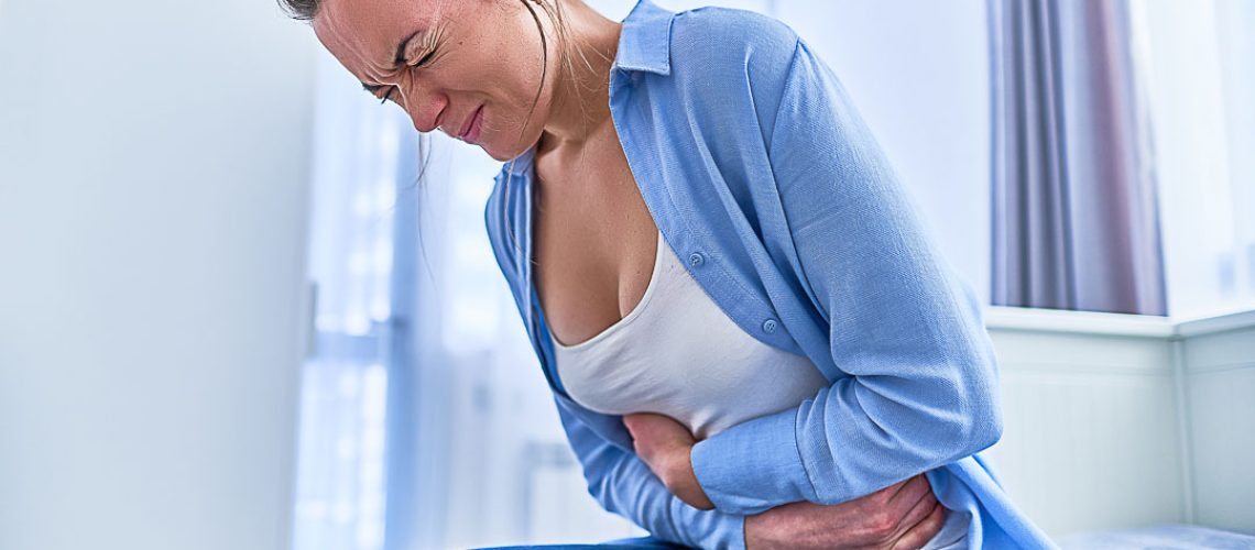 Sick female suffering from stomachache during pain menstruation period or gastrointestinal system disease