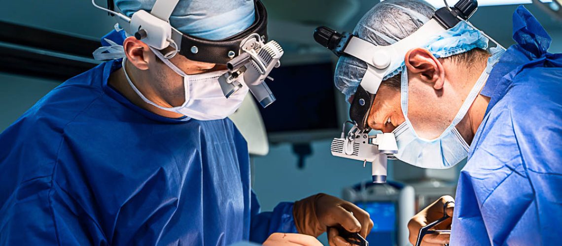 Equipment and medical devices in modern operating room. Operating theatre. Selective focus on neurosurgeons` work.